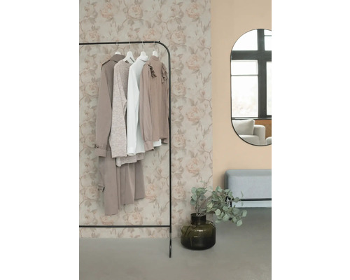 Kledingrek met kleding, spiegel en decoratie in een kamer.