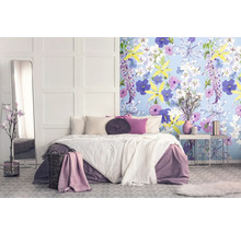 Slaapkamer met tweepersoonsbed, spiegel, nachtkastje en bloemenbehang