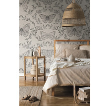 Slaapkamer met bed, nachtkastje, lamp en behang met vlinderpatroon