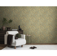 Woonkamer met een groen behang met plantenmotief, een witte fauteuil en een donker dressoir