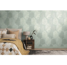 Slaapkamer met behang met motief en een bed met kussens en een deken