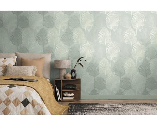 Slaapkamer met behang met motief en een bed met kussens en een deken