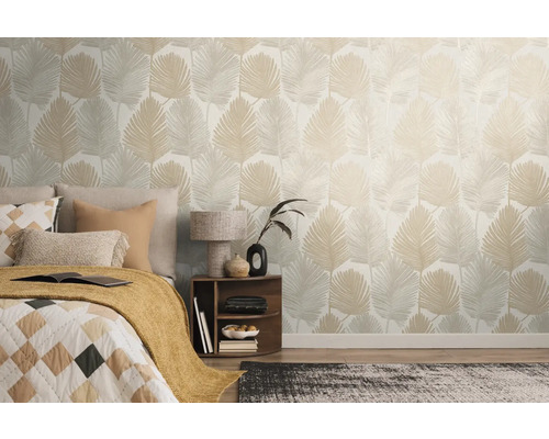 Slaapkamer met bed en een muur met bladerbehang.