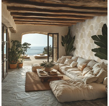 Woonkamer met grote bank, houten balkenplafond en uitzicht op zee