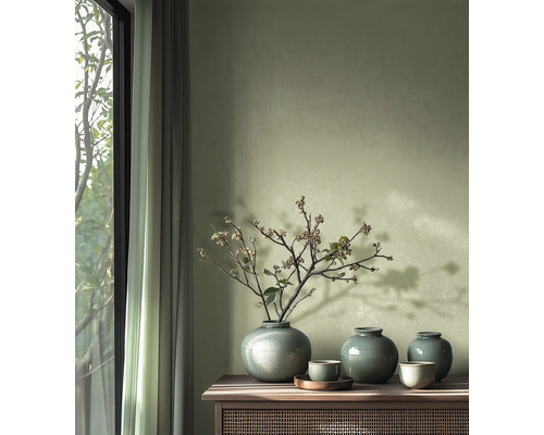 Decoratieve vazen en schalen op een houten kast naast een raam