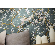 Detailopname van een muur met bloemenbehang, kussens en decoratieve vazen.