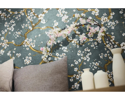 Detailopname van een muur met bloemenbehang, kussens en decoratieve vazen.