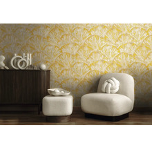 Woonkamer met geel motiefbehang, fauteuil en commode