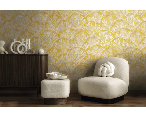 Woonkamer met geel motiefbehang, fauteuil en commode