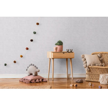 Kinderkamer met houten commode, rotan stoel en decoratieve accessoires