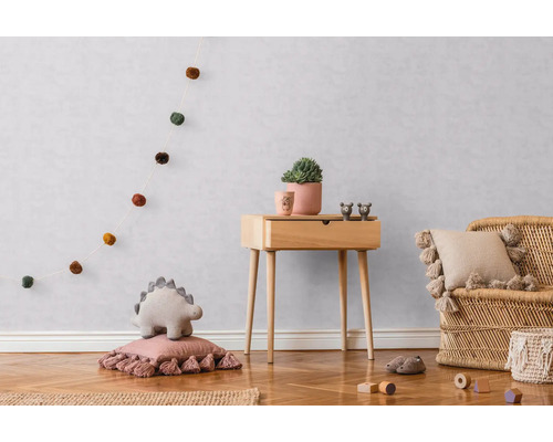 Kinderkamer met houten commode, rotan stoel en decoratieve accessoires