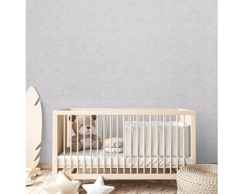 Babykamer met spijlbed, teddybeer en kussens