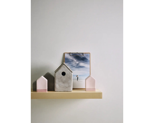 Decoratieve scène met betonnen huisjes en klembord op een plank