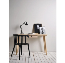 Bureau met lamp, stoel en decoratieve items in een lichte kamer.