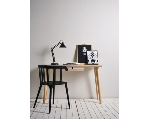 Bureau met lamp, stoel en decoratieve items in een lichte kamer.