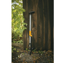 Fiskars onkruidsteker tegen een houten muur