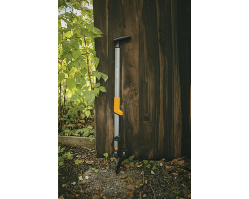 Fiskars onkruidsteker tegen een houten muur
