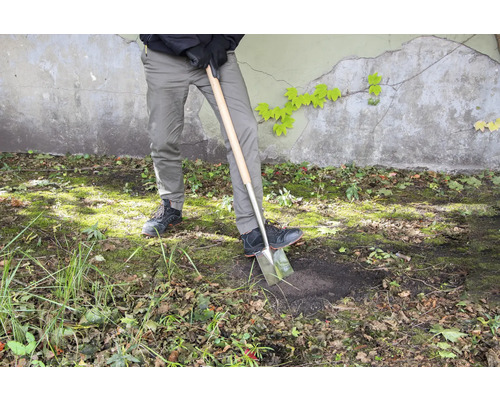 Persoon graaft met een spade in de tuin