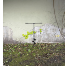 Grondboor in de tuin voor een muur