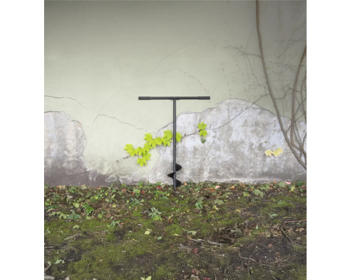 Grondboor in de tuin voor een muur