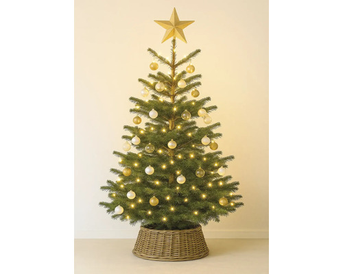 Versierde kerstboom met ster, ballen en lichtjes in een gevlochten mand