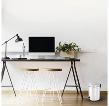 Kantooropstelling met bureau, computer, lamp, stoelen en een afvalemmer met voetpedaal