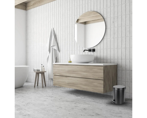 Badkamer met wastafel, spiegel, handdoek, kruk en afvalemmer