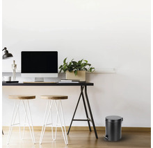 Werkkamer met bureau, stoelen en een ronde pedaalemmer.