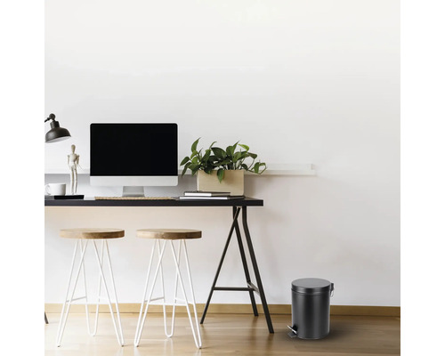 Werkkamer met bureau, stoelen en een ronde pedaalemmer.