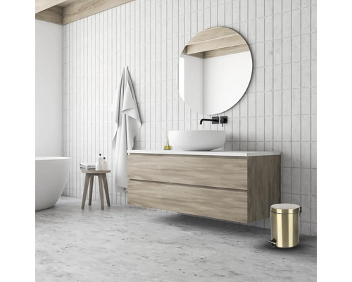 Badkamer met wastafel, spiegel, handdoek, kruk en afvalemmer