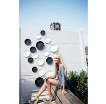 Wanddecoratie met borden in een buitenruimte met een vrouw op een bank