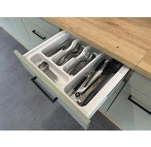 Geopende keukenlade met bestekbak en diverse soorten bestek.