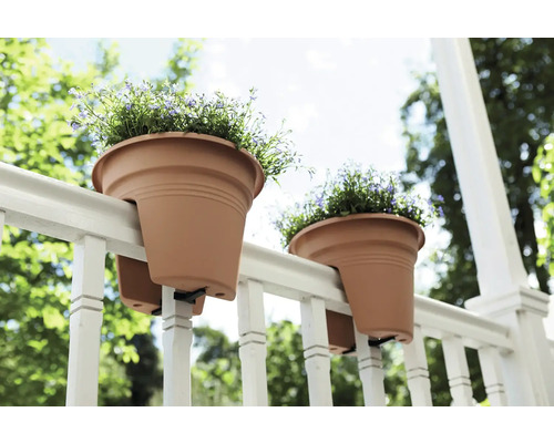 Twee bloempotten hangen aan een reling met bloemen.