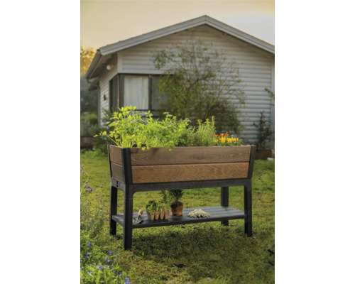Houten en kunststof verhoogde plantenbak met opbergruimte in de tuin