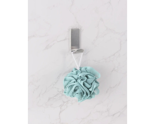 Een badspons hangt aan een haak.