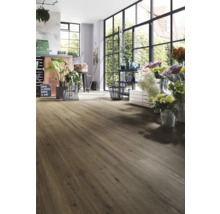 Interieur met laminaatvloer in houtlook en grote ramen.