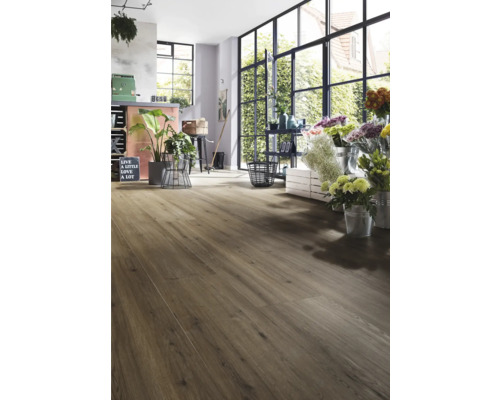 Interieur met laminaatvloer in houtlook en grote ramen.