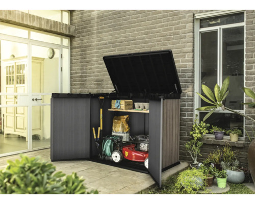 Geopende tuinkast met tuingereedschap en grasmaaier