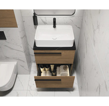 Moderne badkamer met wastafelonderkast, open lade en toilet.