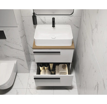 Moderne badkamer met witte wastafel, open lade en marmeren tegels