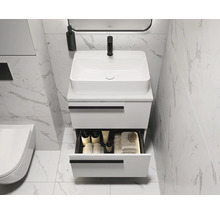 Moderne badkamer met witte wastafelonderkast, open lade en marmeren tegels