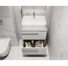 Badkamer met wastafel, onderkast en open lade voor het opbergen van badkamerartikelen