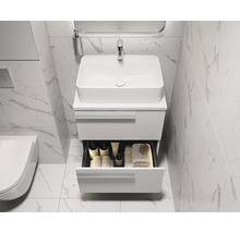 Moderne badkamer met wastafel, onderkast en open lade voor badkamerbenodigdheden