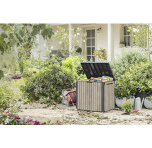Buitentuin met opbergbox, haspel, gieter en planten