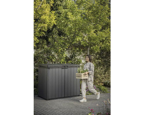 Tuinscene met gereedschapskist en vrouw met houten kist met planten