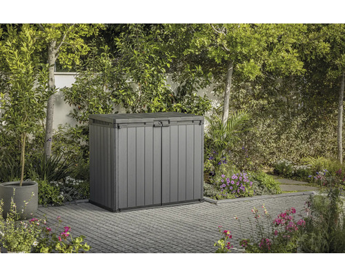Grijze opbergbox in de tuin met omliggende vegetatie