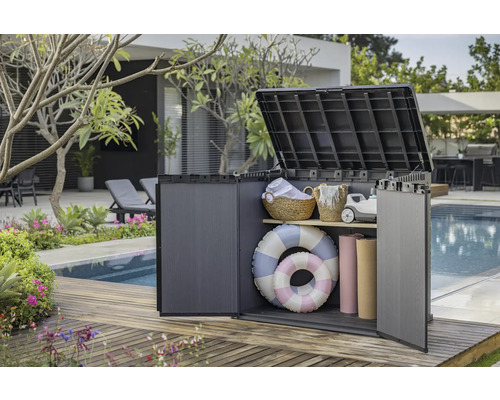 Geopende kunststof opbergbox met zwembadaccessoires in de tuin