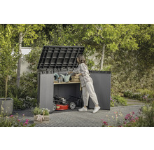 Open tuinkast met tuingereedschap en grasmaaier in de tuin