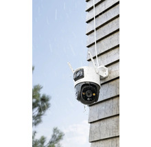 Buitenbewakingscamera aan een huismuur in de regen