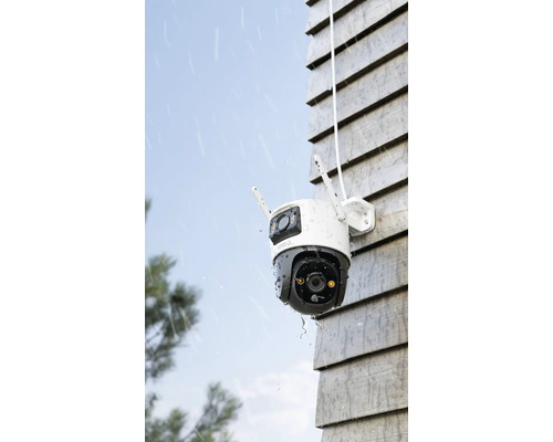 Buitenbewakingscamera aan een huismuur in de regen